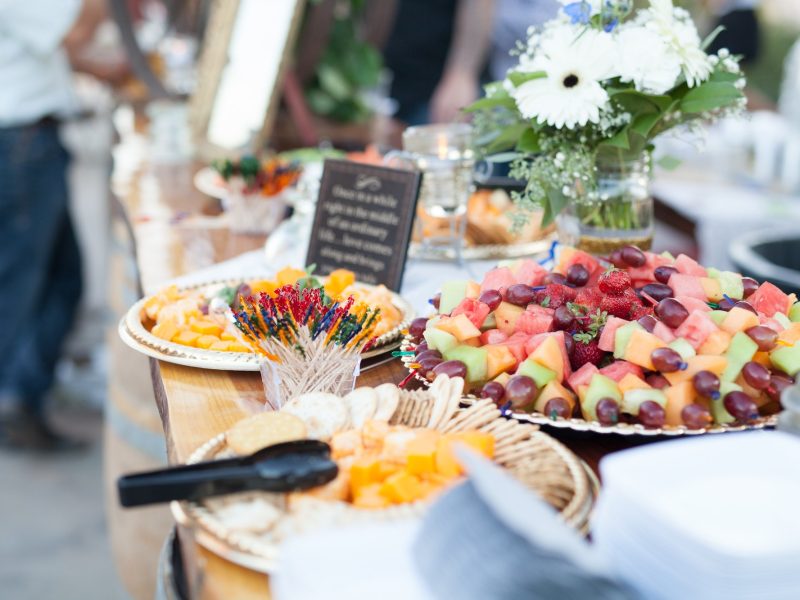 Fresh food sits on a table at an outside event.